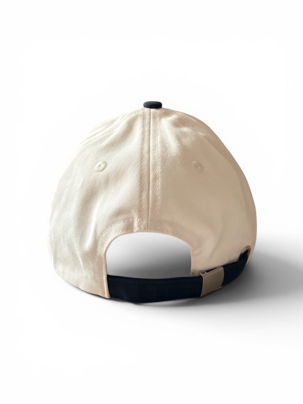 Cream and navy fashion cap, back view, showing plain panel and adjustable strap