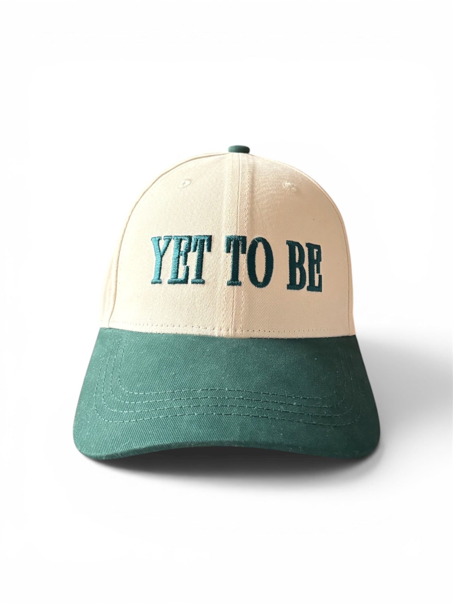Cream and green Yet To Be baseball cap, front view, with YET TO BE embroidered logo