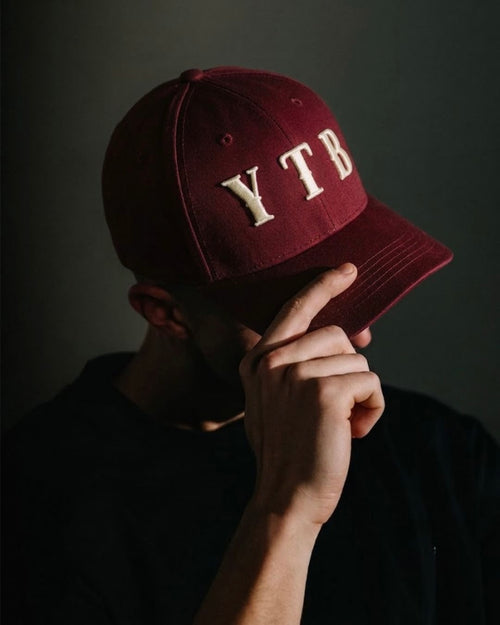 Red YTB streetwear cap worn, lifestyle shot