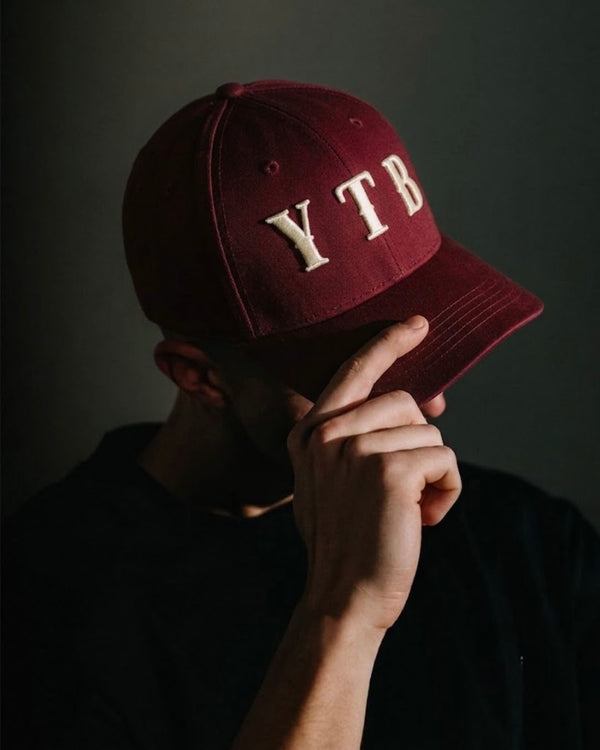 Red YTB streetwear cap worn, lifestyle shot